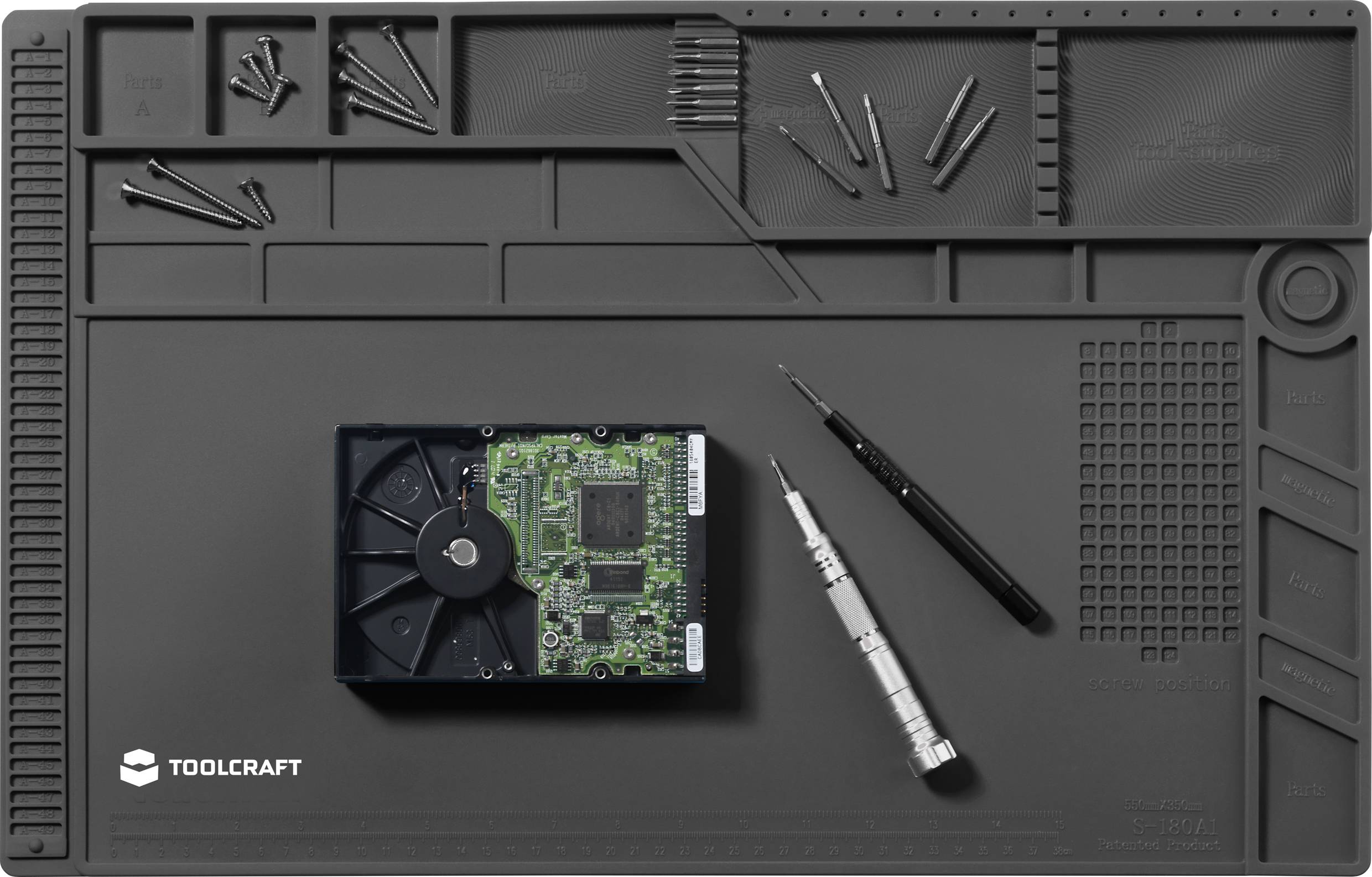 Workshop mat with screws, screwdrivers and hard drive. Tool holders, organised arrangement for repair work.