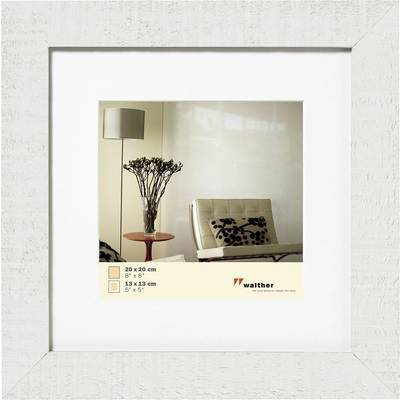 Light-grained wooden frame, containing an image of a minimalist living room with a white armchair, side table, and plant.
