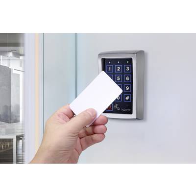 A hand holds an access card in front of an electronic keypad lock on a door, ready to use the access control system.