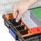 A hand arranges black dividers in a sorting tray with coloured compartments in grey, red, green, orange, and blue.