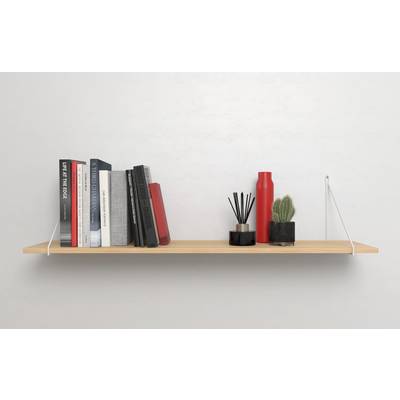 Minimal wall shelf with books on the left and a red vase, reed diffuser, and small cactus on the right against a white wall.