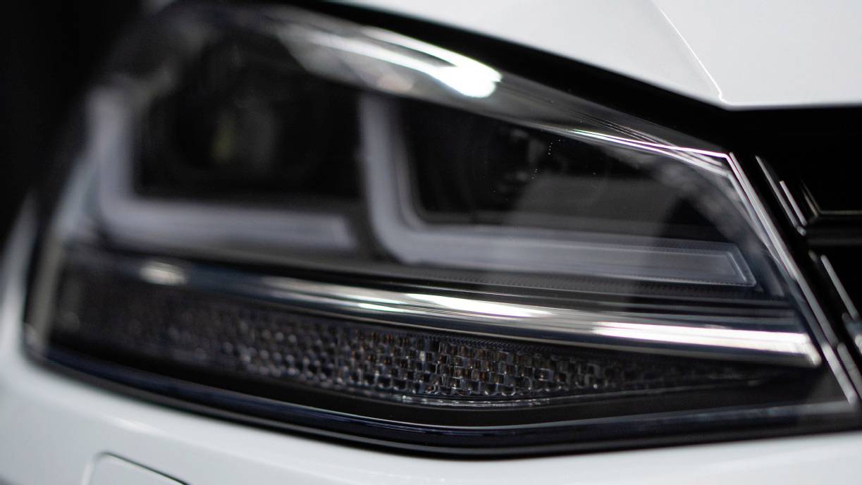Close-up of a modern car headlight with clean lines and an elegant form, demonstrating technological advances in vehicle design.