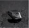 A black, triangular, waterproof-coated small box with the inscription 'Midland' is located on a wet dark surface.