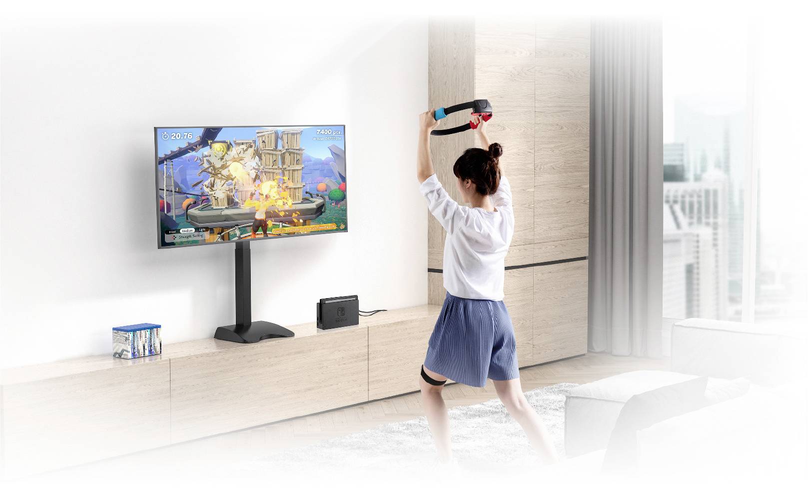 A person is playing a fitness video game in the living room, using motion controllers and ring accessories, looking at the television.
