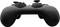 A black video game controller with two joysticks and multiple buttons is lying on a flat surface.