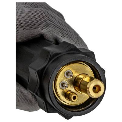 Close-up of a gloved hand holding a black connector with a gold circular face and three metal contact pins.