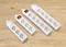 Four white power strips with varying numbers of sockets and red on/off switches on a wooden surface.