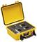 A yellow portable testing device with an open lid. Black control panel with various switches and rotary controls.