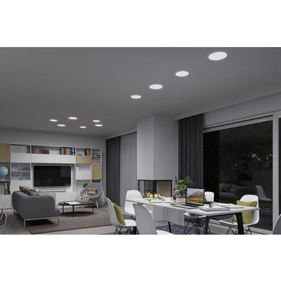 A modern living room with a grey sofa, fireplace and dining table with laptops, bookshelves and ceiling lights.