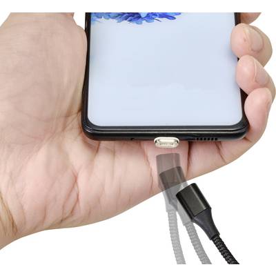 A smartphone is being held in hand; a charger approaches the charging port, indicating an impending charging process.