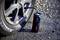 'Small digital air compressor connected to a car tyre, displaying 3.00 bar pressure, on an asphalted surface.'