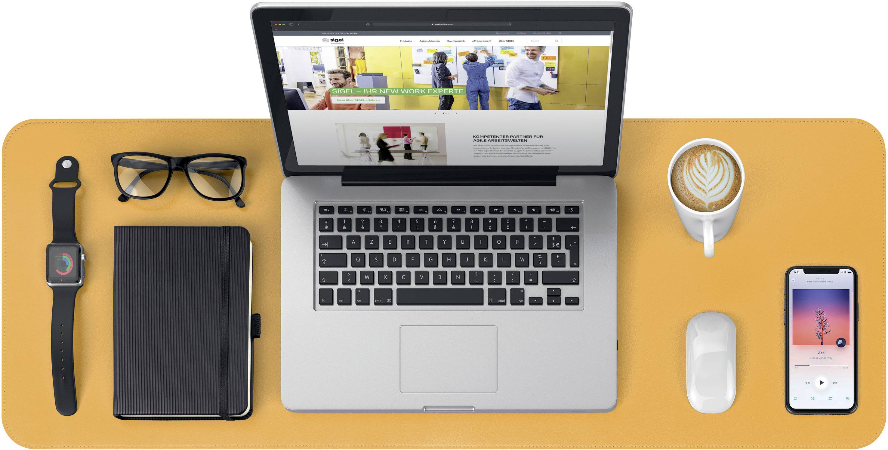 Laptop on an orange table, open with a website displayed. Beside it, glasses, smartwatch, notebook, coffee cup, mouse and smartphone.