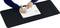 A person is writing with a pen in a notebook on a large black desk mat.