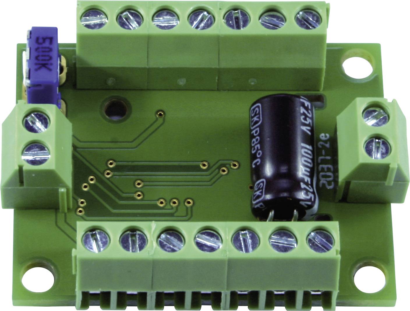 A green electronic circuit with multiple terminal blocks, a blue potentiometer, and a black capacitor.