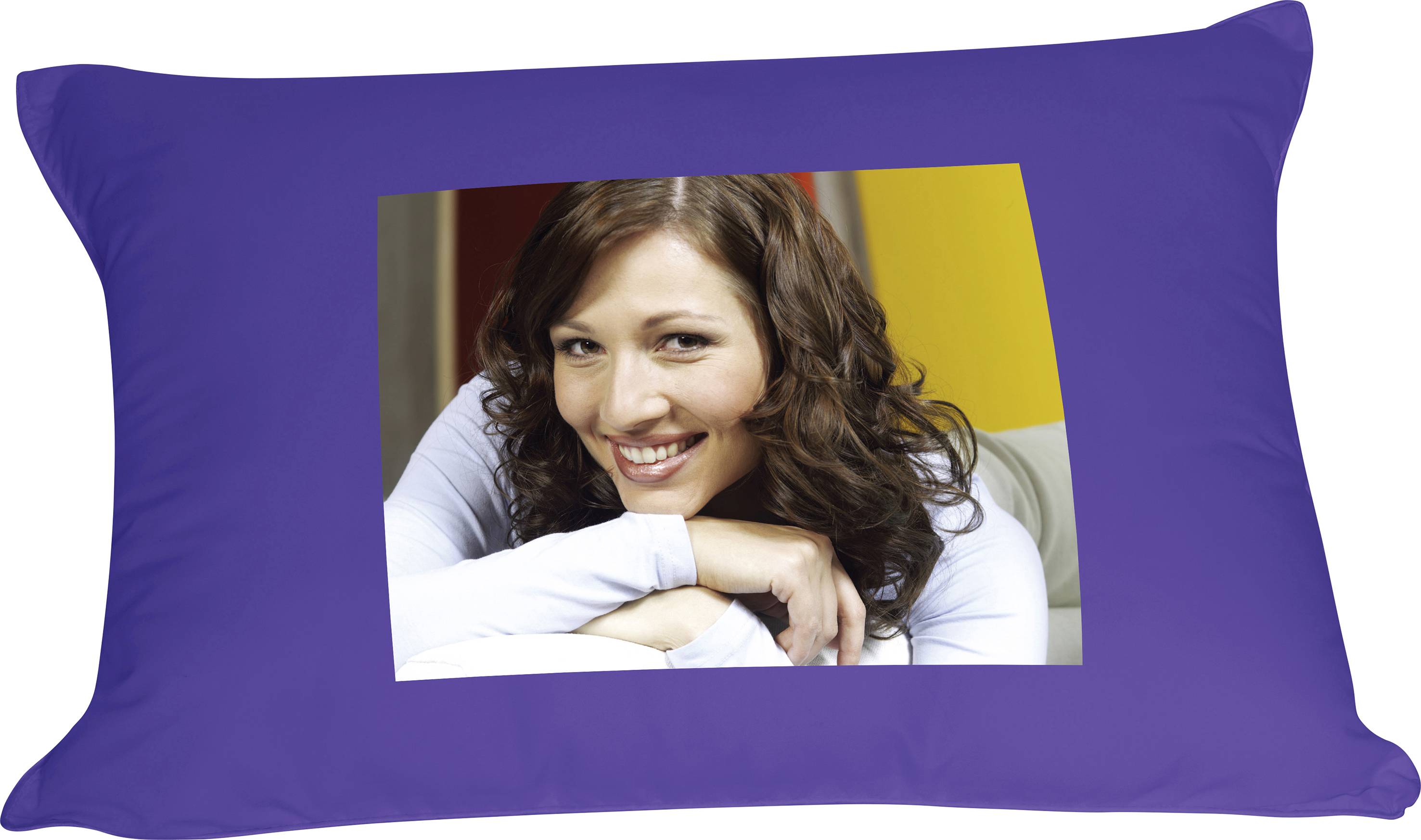 A woman with curly hair smiles at the camera, leaning back with her arms crossed on a sofa. Background in red and yellow.