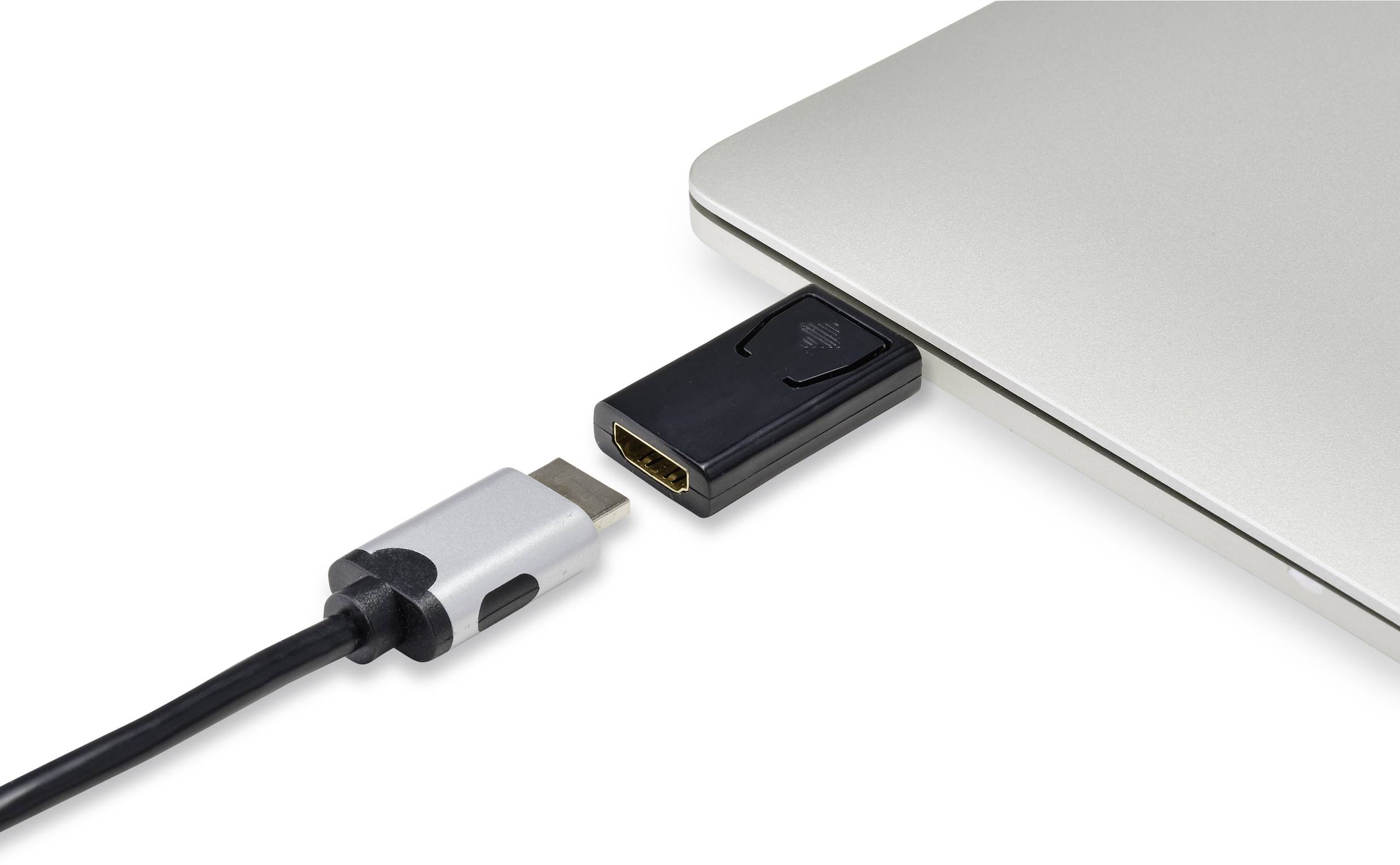 A USB-C cable is plugged into an adapter that fits into a laptop port. The laptop is silver in colour.