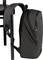 Grey backpack hangs on the back of a black chair. The backpack has red accents and is slightly open.