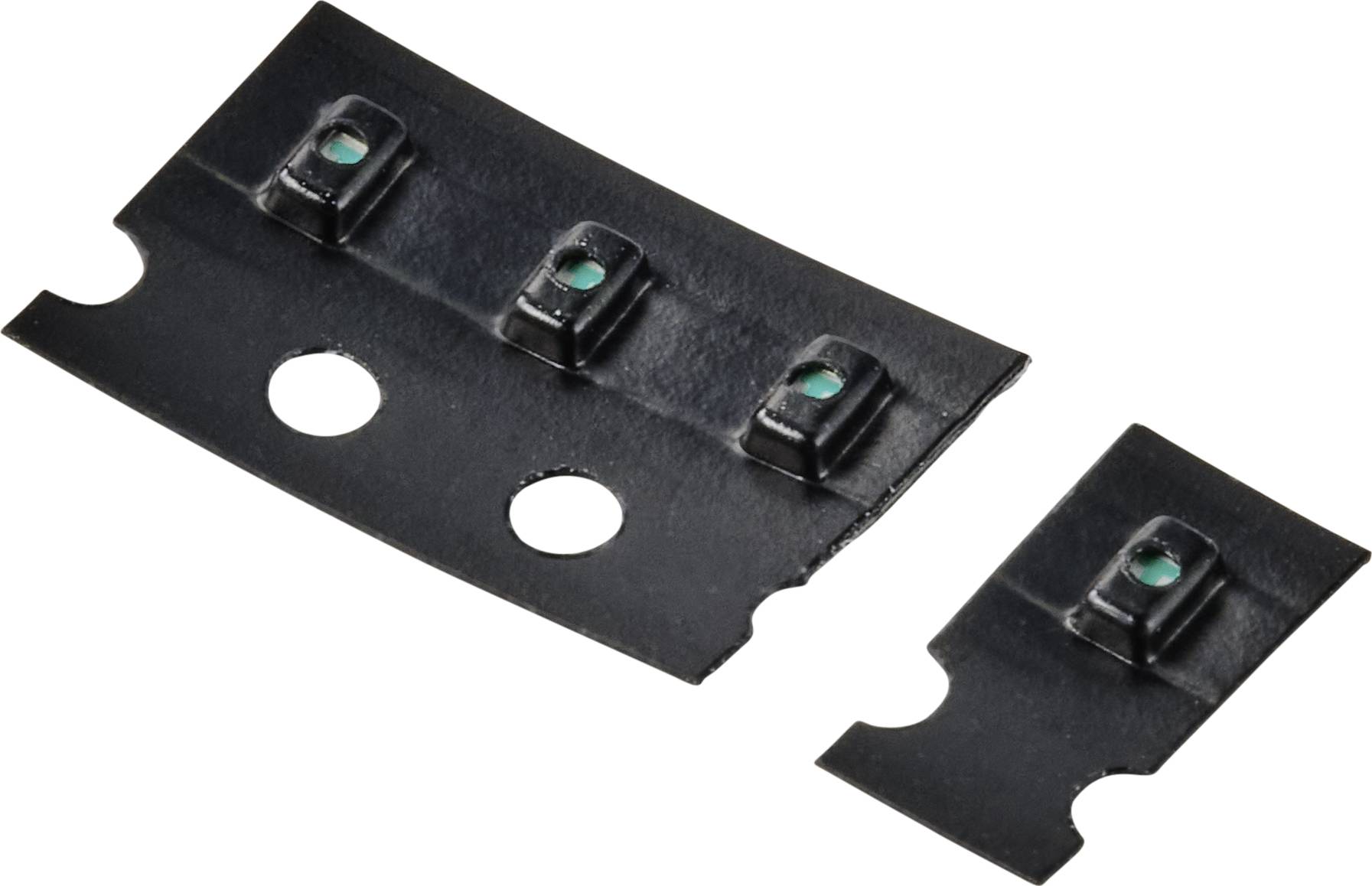 Two black, rectangular plastic components with green LED lights recessed in the mat, identifiable by round holes.