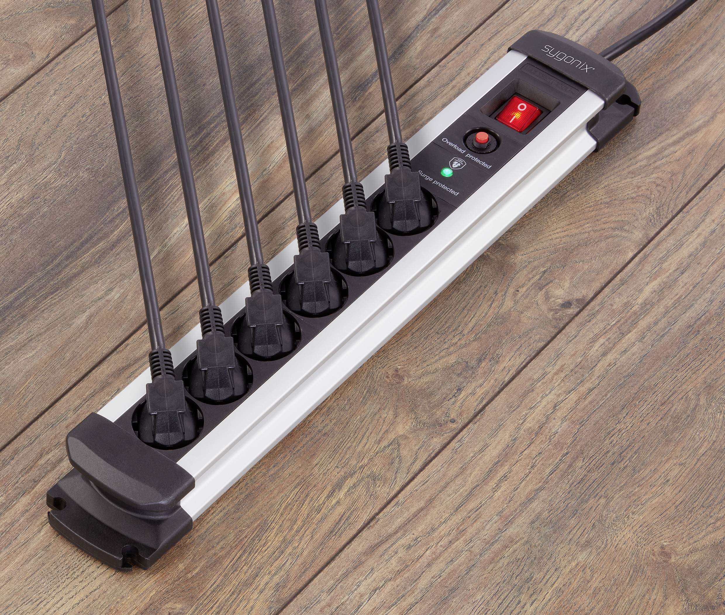 Multi-socket extension lead with seven occupied connections on wooden flooring, switch and LED indicator for operation.