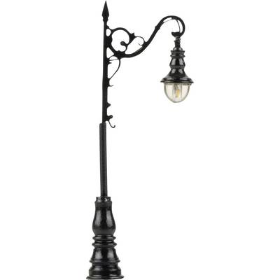 An elegant, black street lamp in an antique style with a curved arm and glass lampshade.