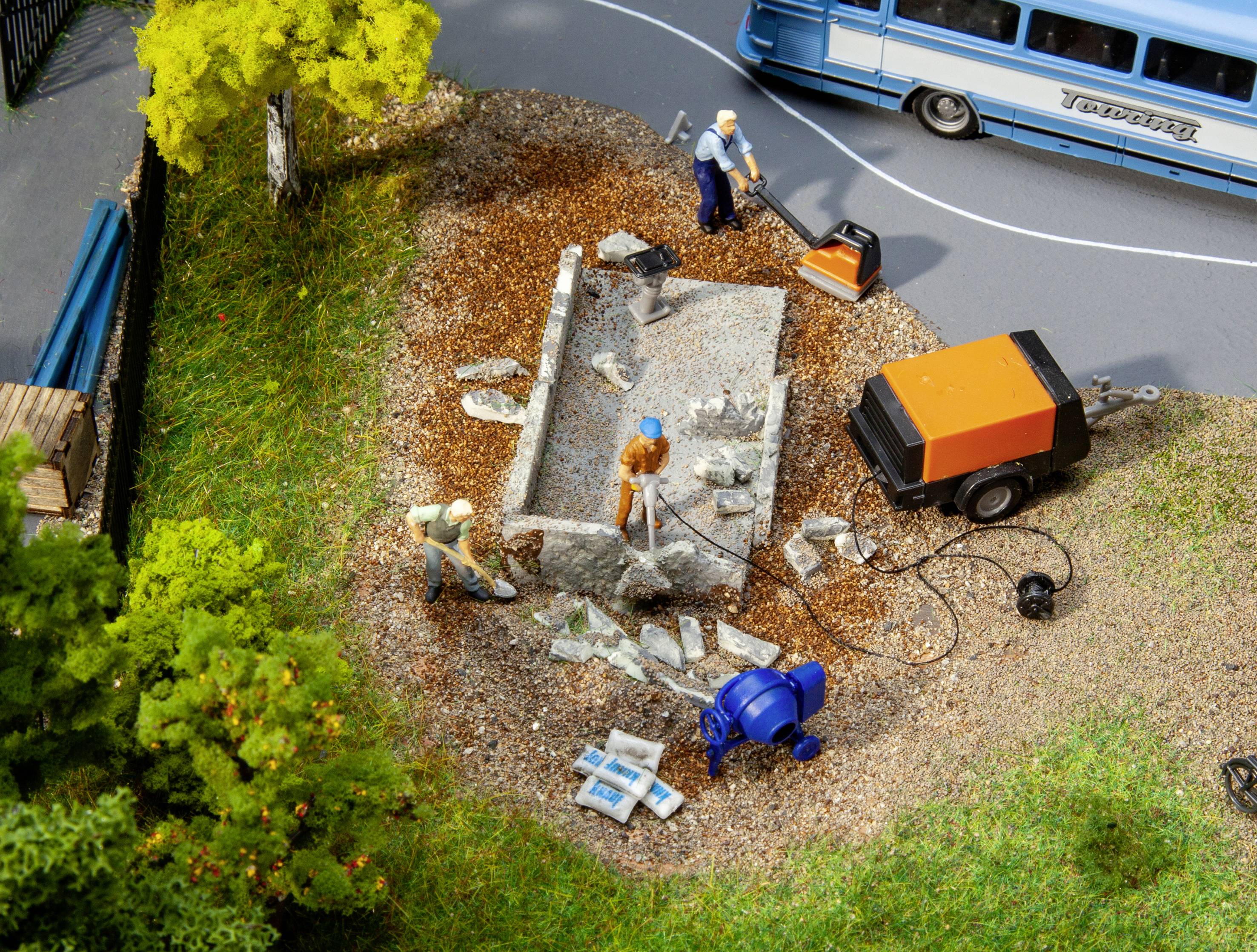 Construction workers on a building site, working on a foundation with shovels and tools, surrounded by machinery and vehicles.