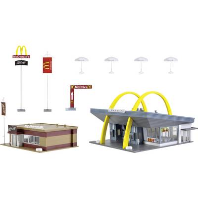 A model of two McDonald's buildings: one in a retro style with yellow arches and one of a more modern style, plus signage.