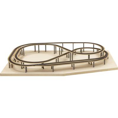 A miniature model of a racing car track in the shape of a figure eight on a wooden board. The circuit has multiple levels and supports.