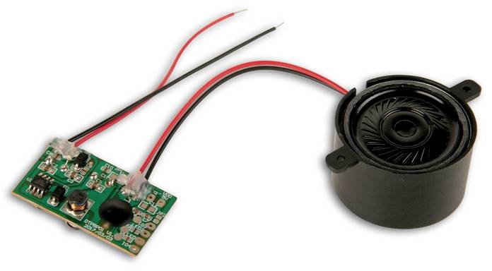 Electronic component with a small speaker unit and a circuit board connected by two cables.