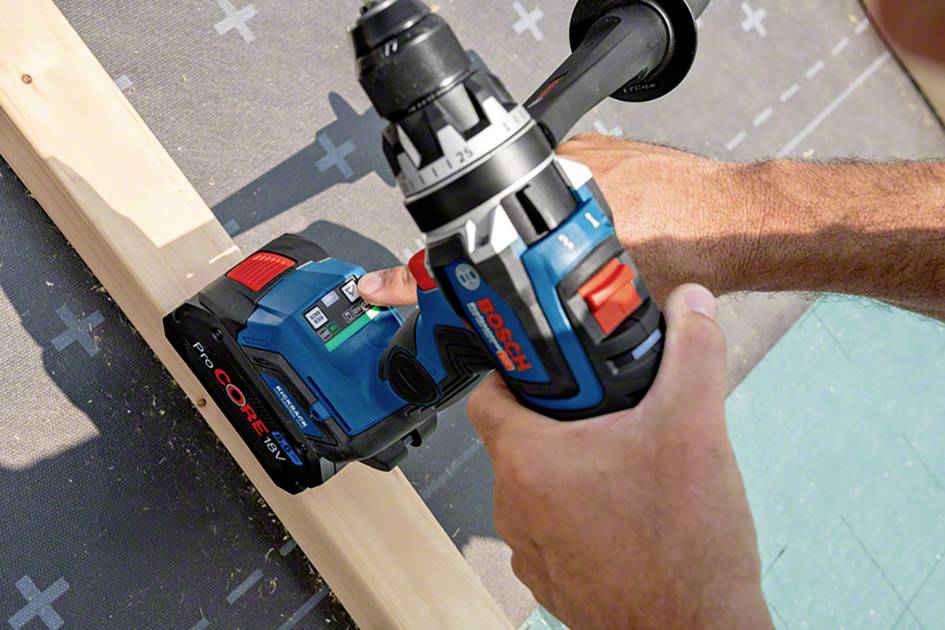 Close-up of a person using a blue cordless drill to work on a wooden board. The drill bears the logo of a well-known brand.