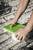 A person is installing a green cover on a white electrical socket embedded in a concrete floor.