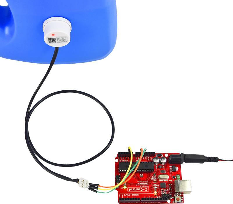 A red Arduino board is connected to a blue container. A sensor is attached to the container and linked to the board via a cable.