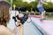 A person is filming a skateboarder in a skate park. The rider is performing a trick on a ramp in the background.