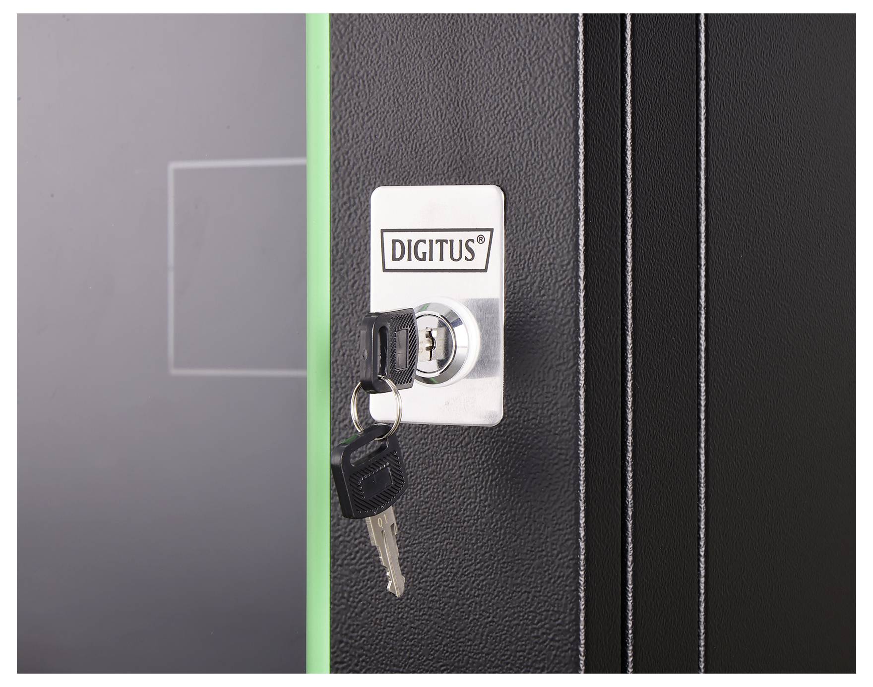 A close-up image of a lock with a key inserted. The lock has the label 'DIGITUS' on it, and is part of a textured black surface.