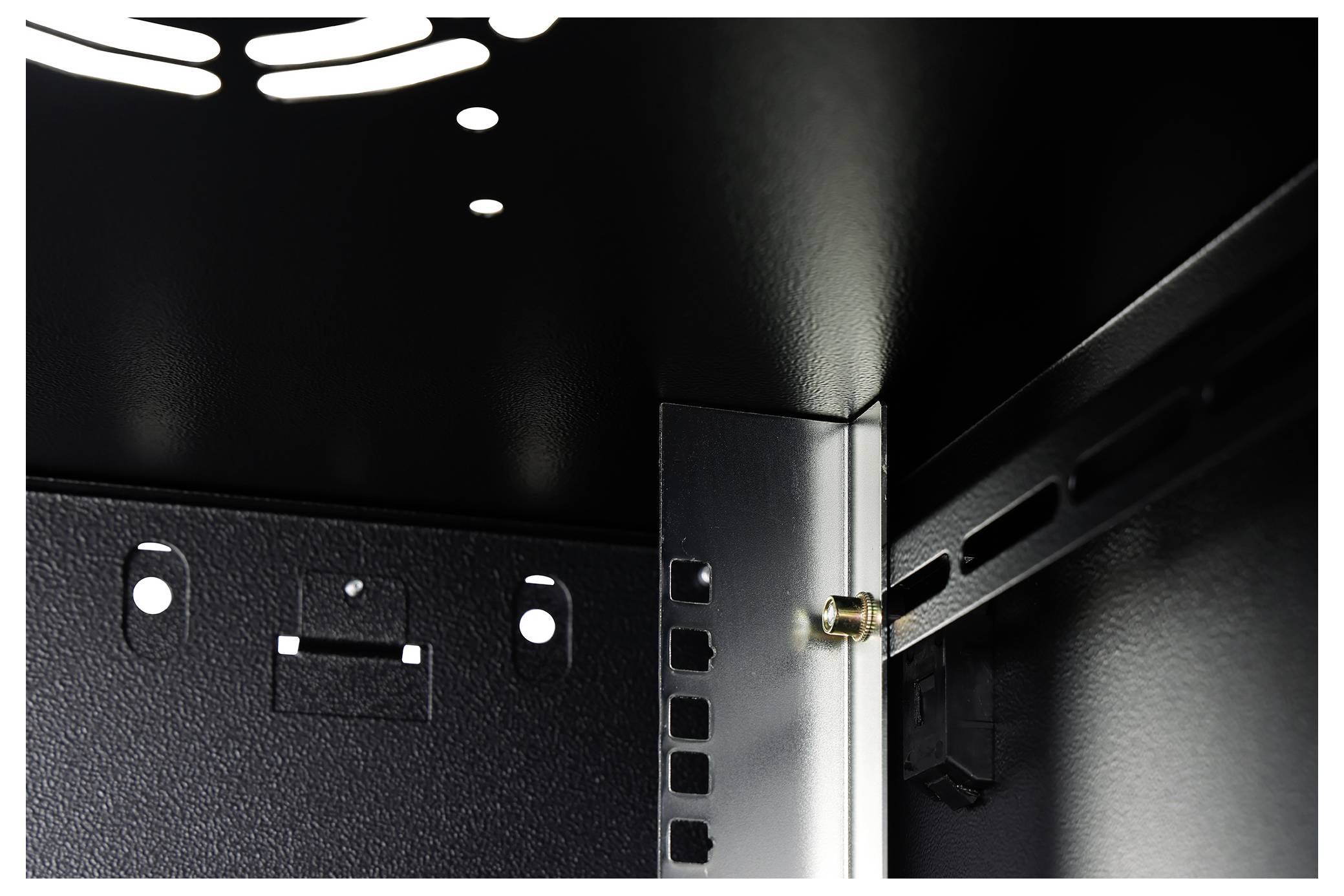 The image shows the interior corner of a metallic cabinet, highlighting the structural support with rivets and perforated panels for ventilation.