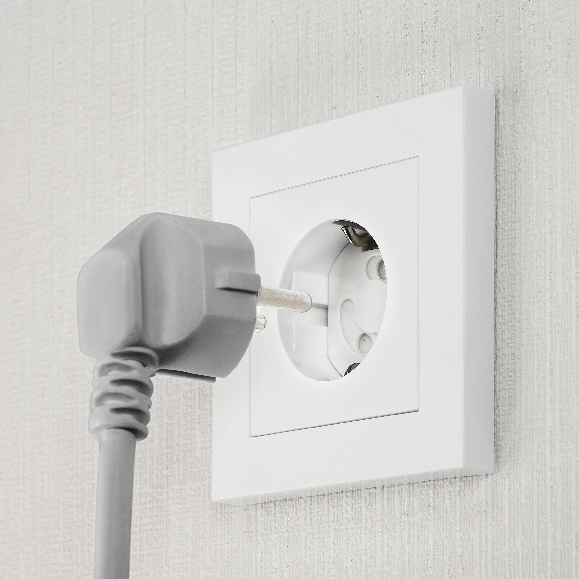 Socket on the wall with a plug inserted.