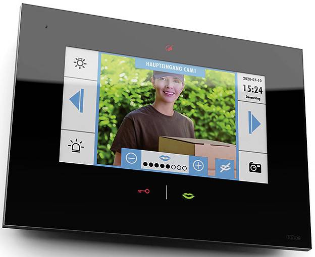 A person is holding a package in front of a camera on an intercom system. The display reads 'Main Entrance Cam1' with time and date.