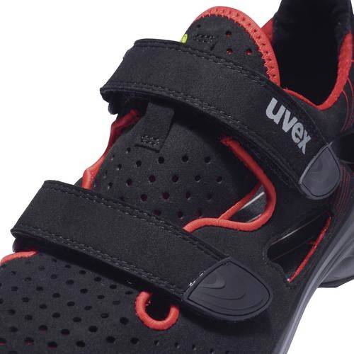 Black safety shoe with red accents and hook and loop fastening. 'uvex' brand name visible. Suitable for occupational safety.