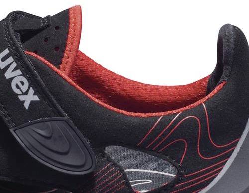 A black shoe with red accents and a touch-and-close fastening, with 'Uvex' printed on it. Sporty design, decorative side stitching.