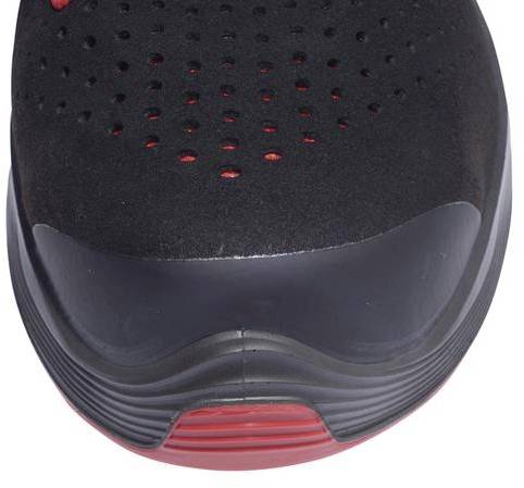 Black sports trainer with red accents and perforated surface, showing the toe cap and sole for ventilation and design.