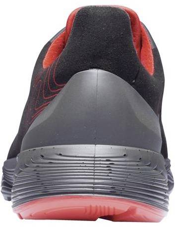 A pair of trainers, black with red accents, photographed from behind. The sole is textured and grey.