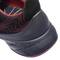 Rear view of a black sports shoe with red accents and wave-like lines. The shoe has a robust, black sole.