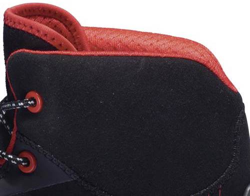 A black shoe with red accents on the collar and laces, a detailed close-up of the upper and eyelets.