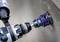 A drill with a hole saw attachment is drilling a hole in a concrete wall.