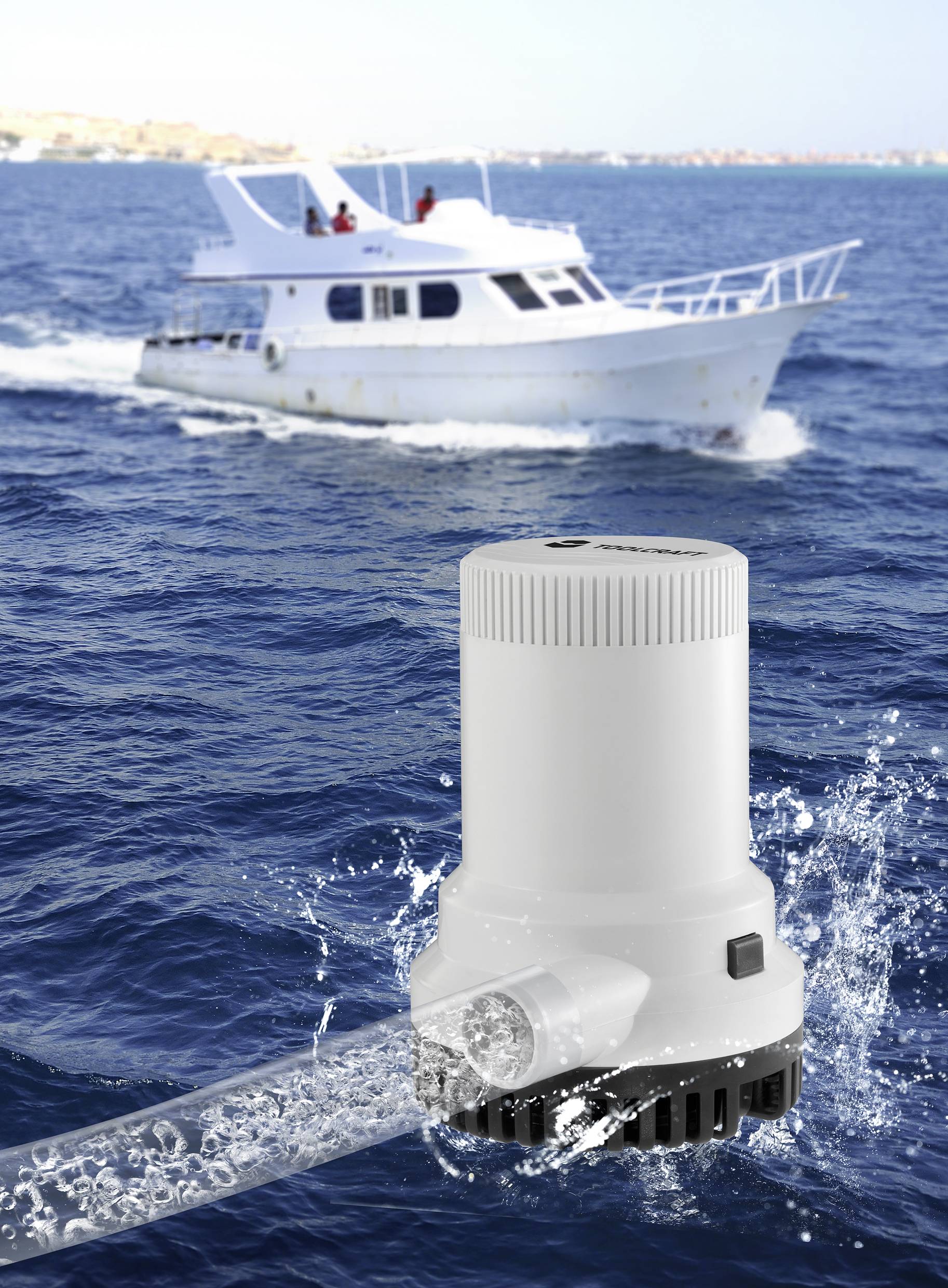 A white boat sails on the open sea. In the foreground, a white water pump is pumping water, indicating its functionality.