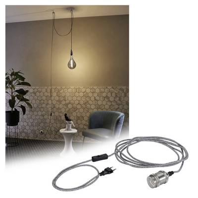 Pendant light with textile-covered cable, hanging from the ceiling above a table with decorative items in a modern interior.
