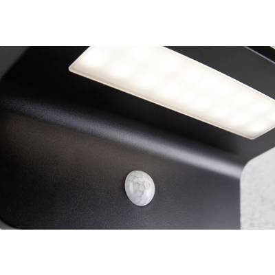 A black outdoor light with an integrated motion sensor is shining brightly.