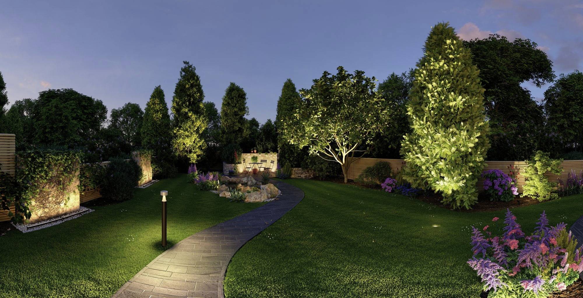 Illuminated garden at dusk with a winding path, surrounded by trees and flowering shrubs.