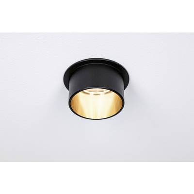 Recessed light fitting with a black housing mounted on the ceiling. It emits a warm, soft light.