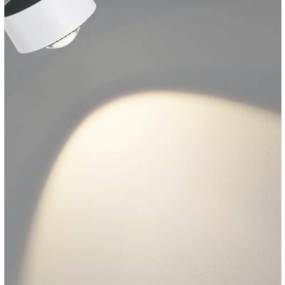 A lamp casts light onto a wall, creating a bright light patch and contrasting with the darker surroundings in the room.