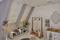A stylishly decorated loft room with a dressing area. Clothes, hats, and scarves are decoratively arranged on shelves and stands.